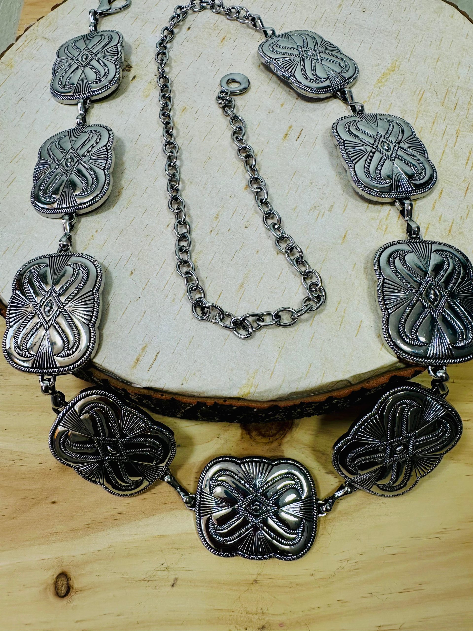 Cinturón con aplicaciones cuadradas metalicas. Cierre con cadena y mosquetón. Oliva Valencia