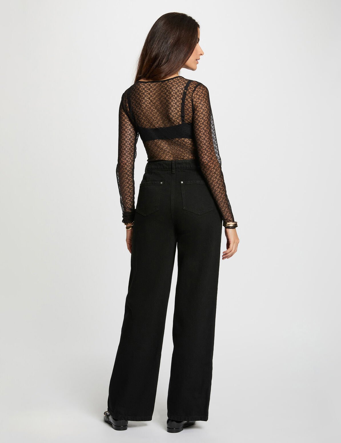 La camiseta corta y entallada se combina con un pantalón ancho de talle alto, unos mocasines de charol y una acumulación de pulseras para un estilo femenino y seguro. Oliva Valencia