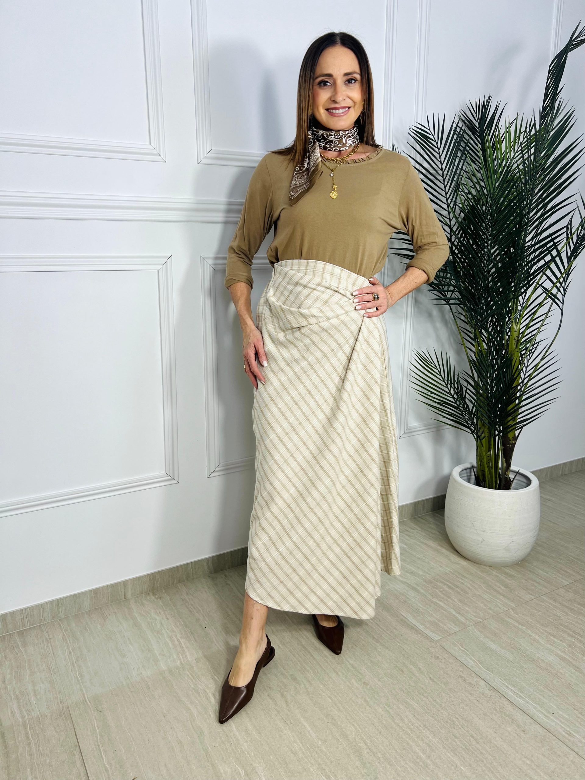 Descubre la Falda Midi Celia en tonos arena y beige. Un diseño con corte asimétrico y estampado de cuadros que aporta calidez y elegancia a tu estilo diario. ¡Un básico imprescindible! Oliva Valencia Original Regals La Safor Moda Ropa